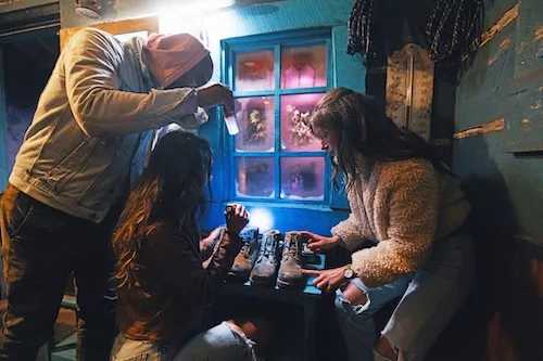 Group of people looking down at clues holding flashlights to try figure out how to leave the Escape Room on Times Square