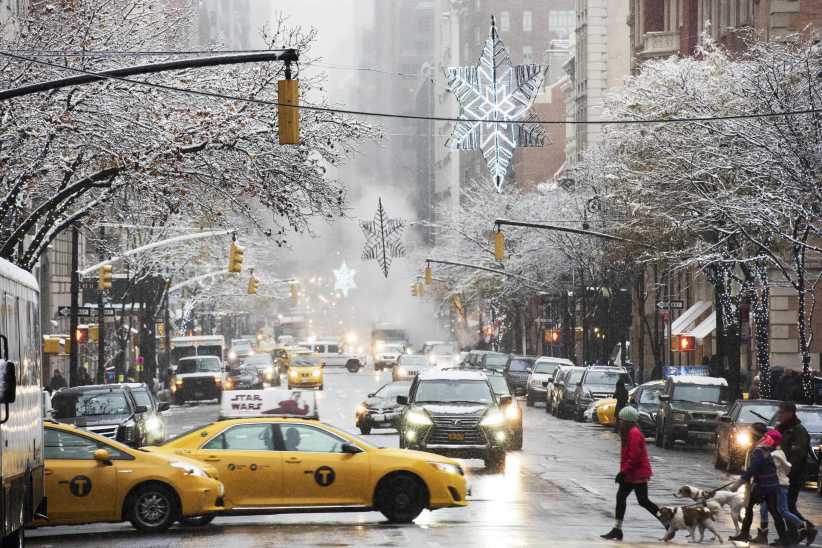 Beautiful, snowy overview shot of Madison Avenue, with yellow taxi and pedestrians crossing the street, part of NYC Winter Outing