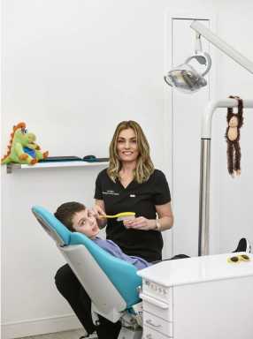 Dentist with patient sitting in dental chair