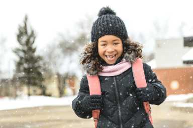 A young child leaving school with a backpack for February mid-winter break NYC