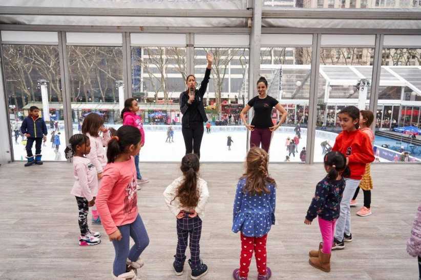 Children standing in a circle participating in an activity.