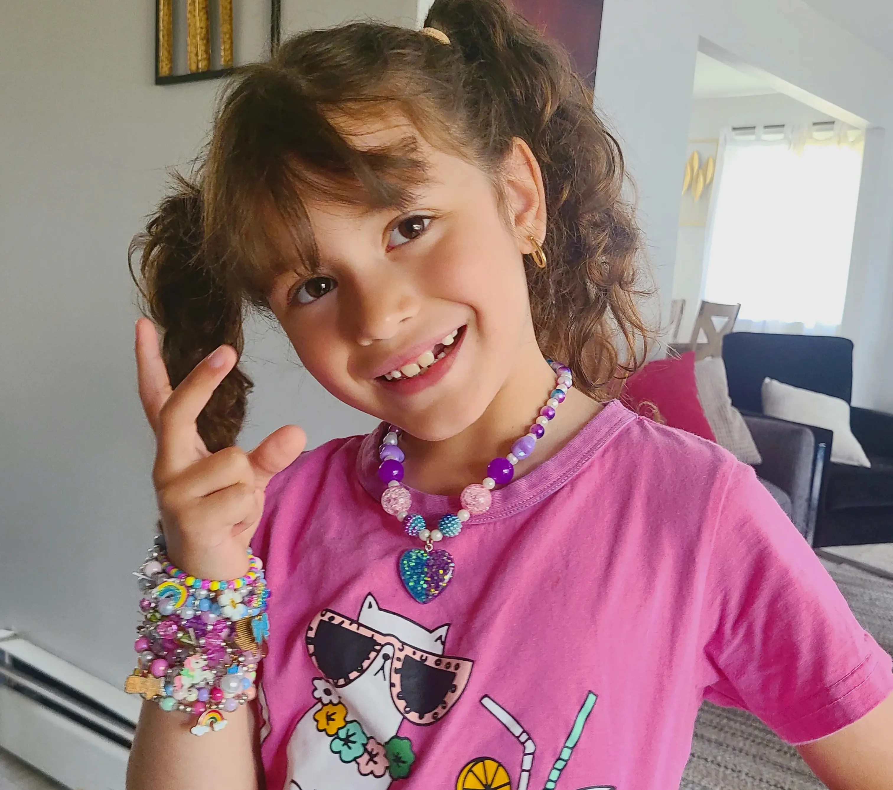 Adorable Quiet Play Ideas for Kids That Encourage Calm, Creativity & Confidence: girl posing with her own creation of bracelets and necklaces