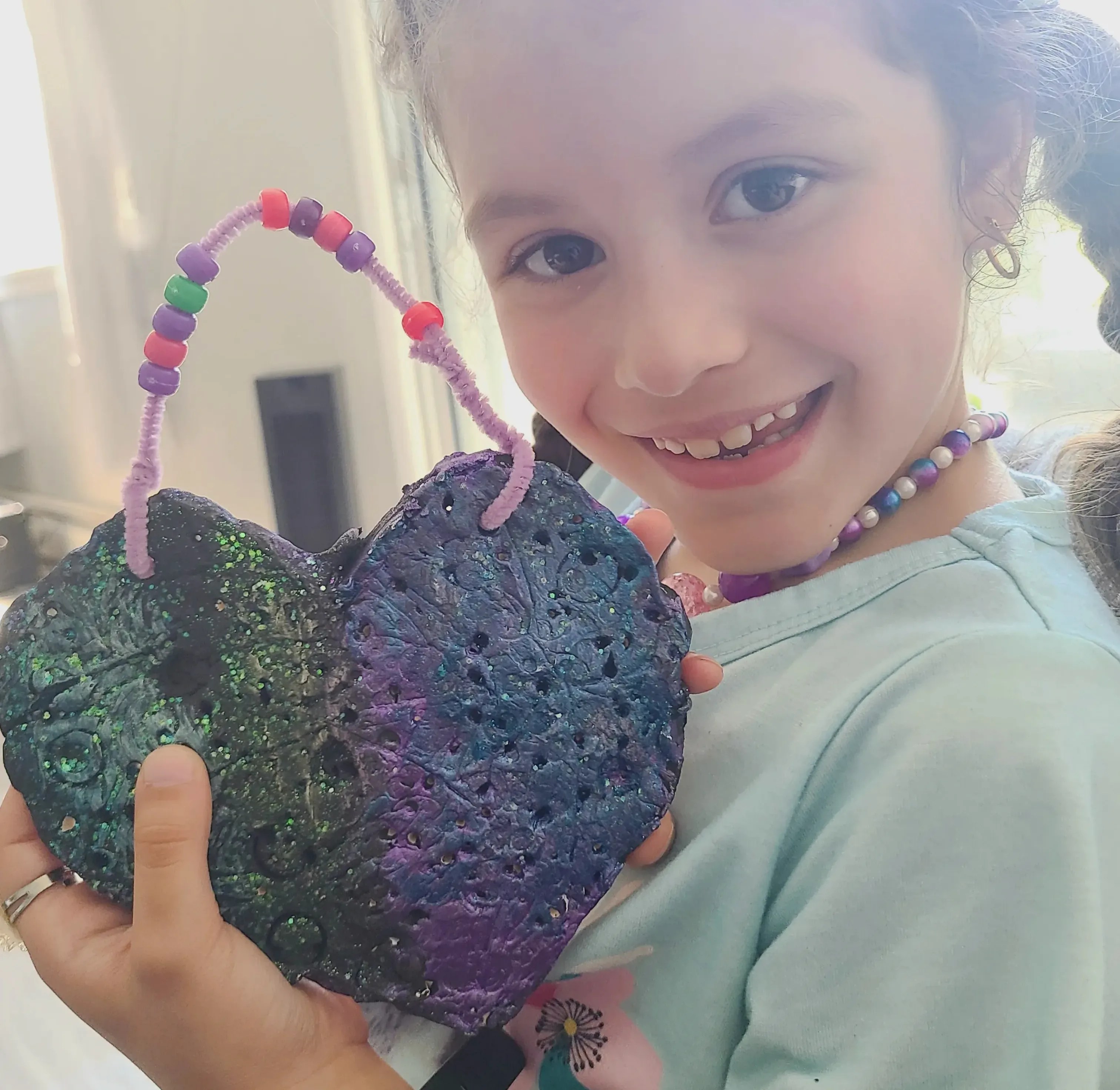 Adorable Quiet Play Ideas for Kids That Encourage Calm, Creativity & Confidence: girl posing with a clay creation